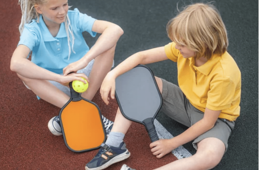 kids sitting on pickleball court