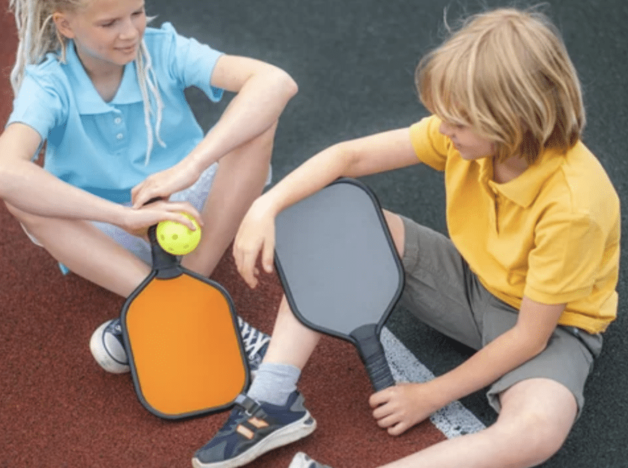 kids sitting on pickleball court